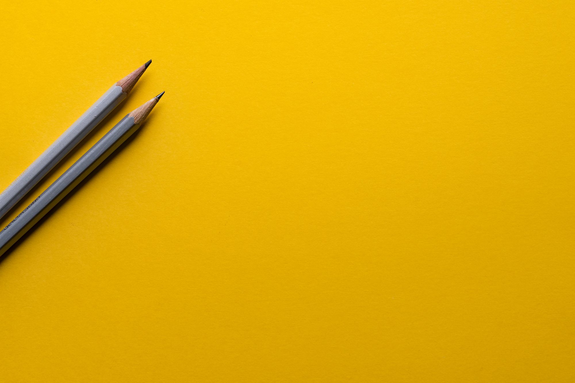 Stock photo of pens on yellow background.