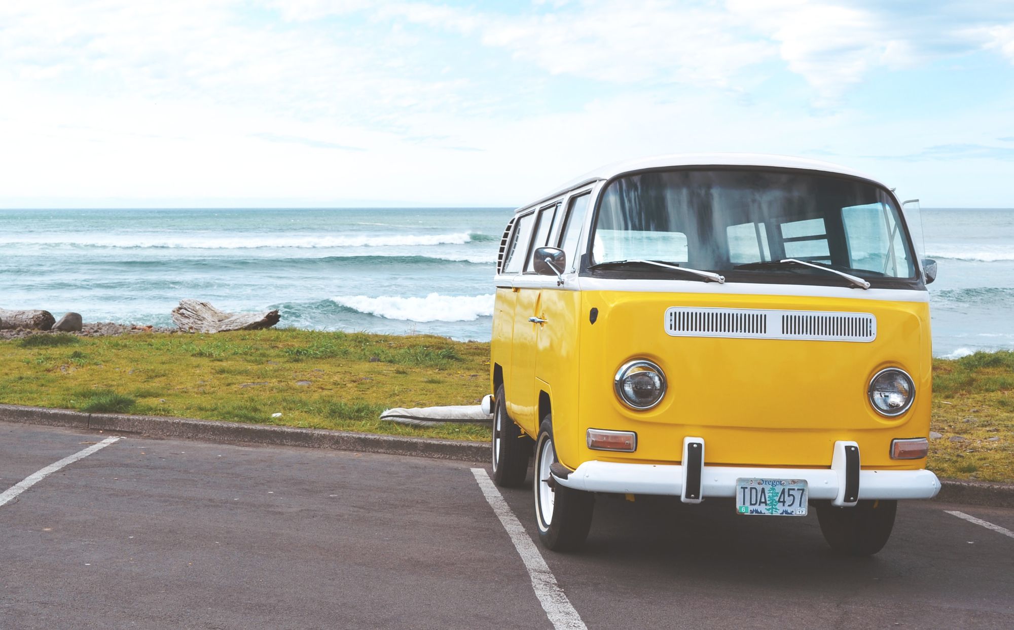 Stock photo of vintage yellow van at beach.