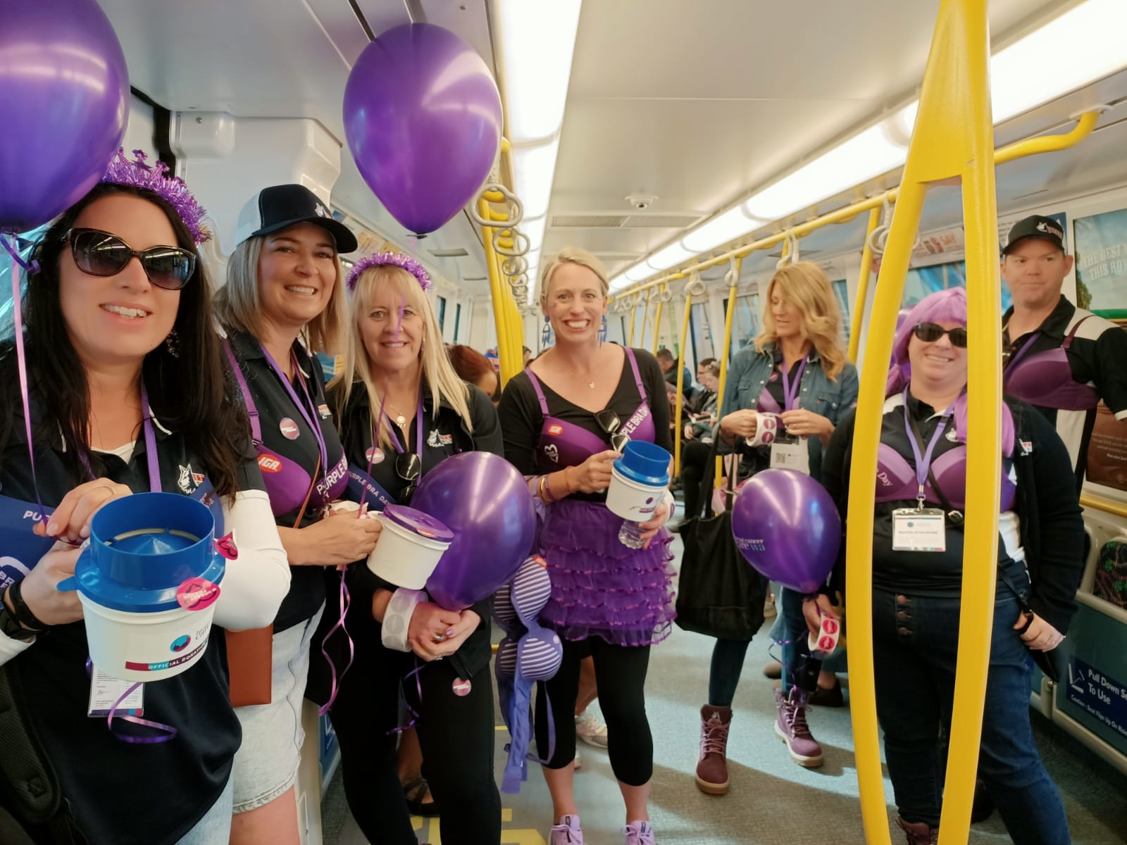 Purple Bra Day volunteers on the train asking for donations.