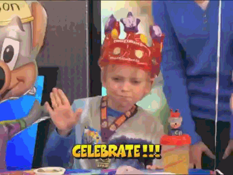 GIF of a kid celebrating with a party hat on.