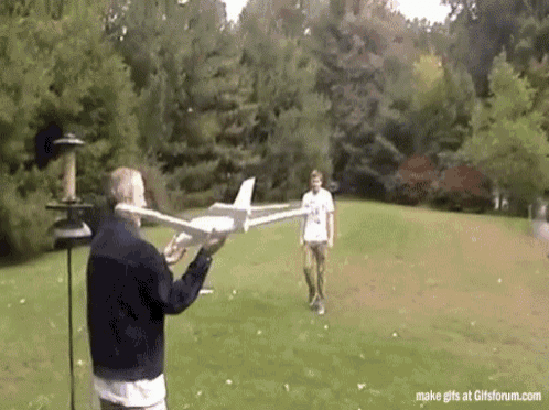GIF of a person flying a toy plane and then hitting him in the head.
